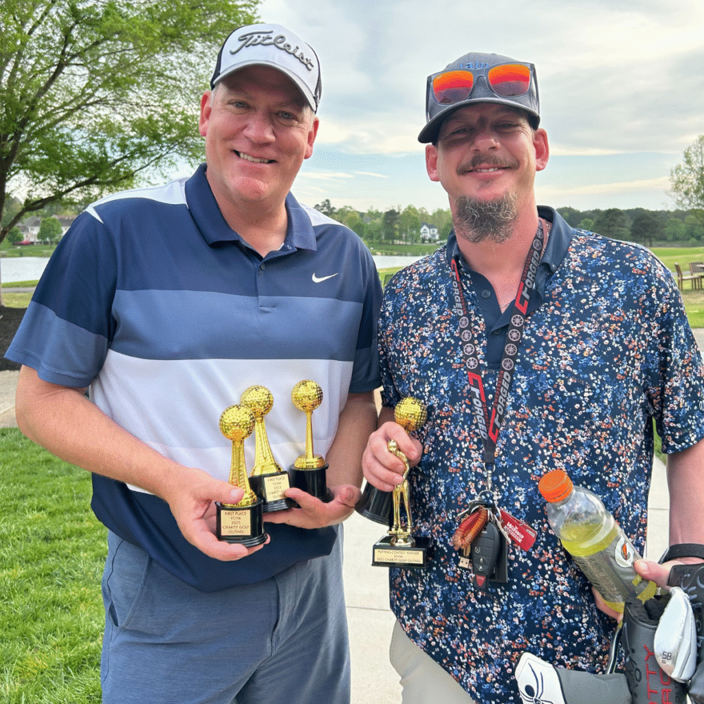 Two men holding small gold trophies