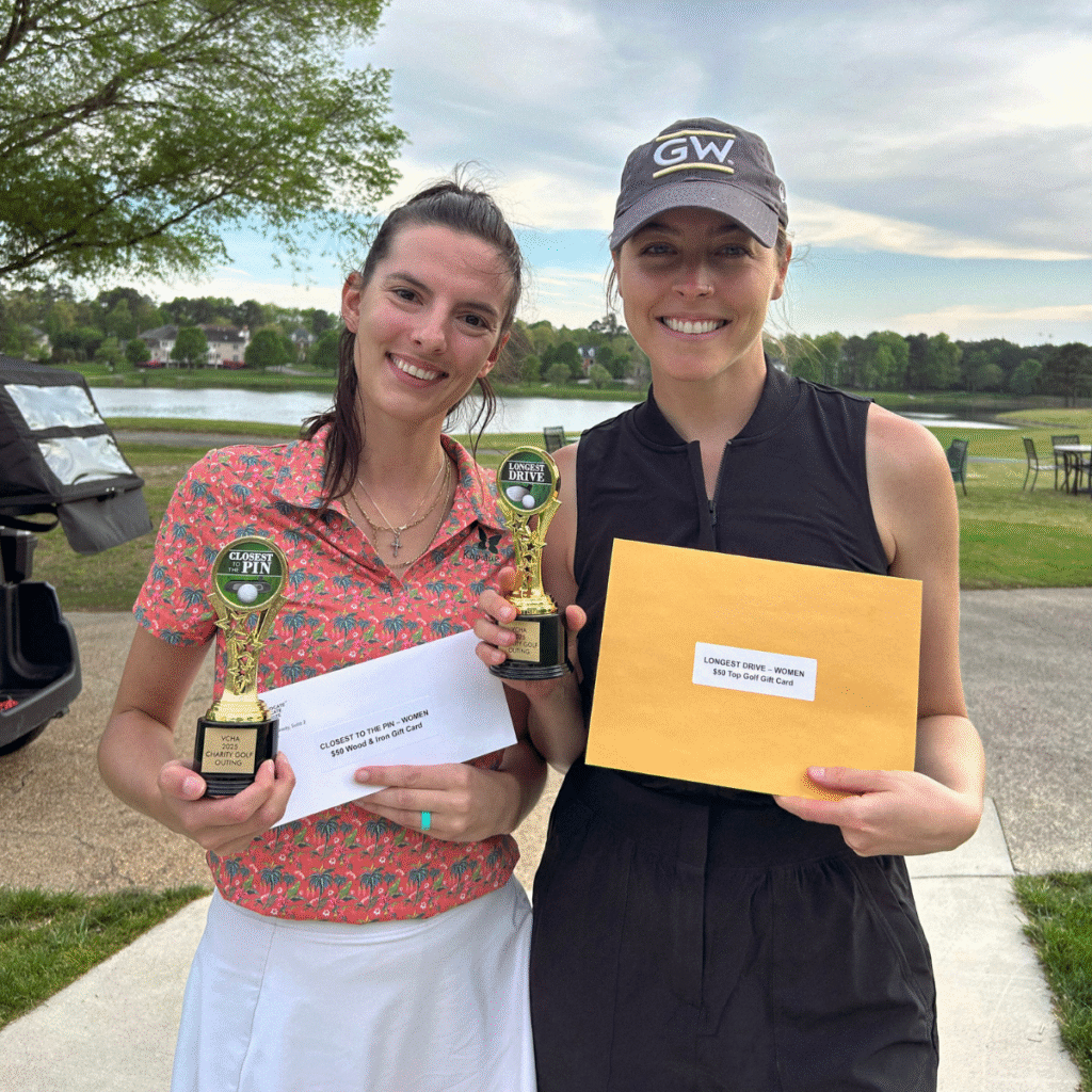 Two women smiling holding trophies and envelopes