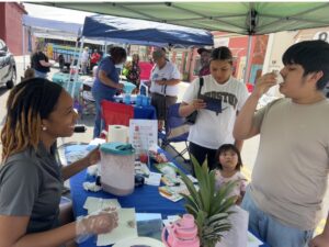 Adrienne tabling at a member health center block party.