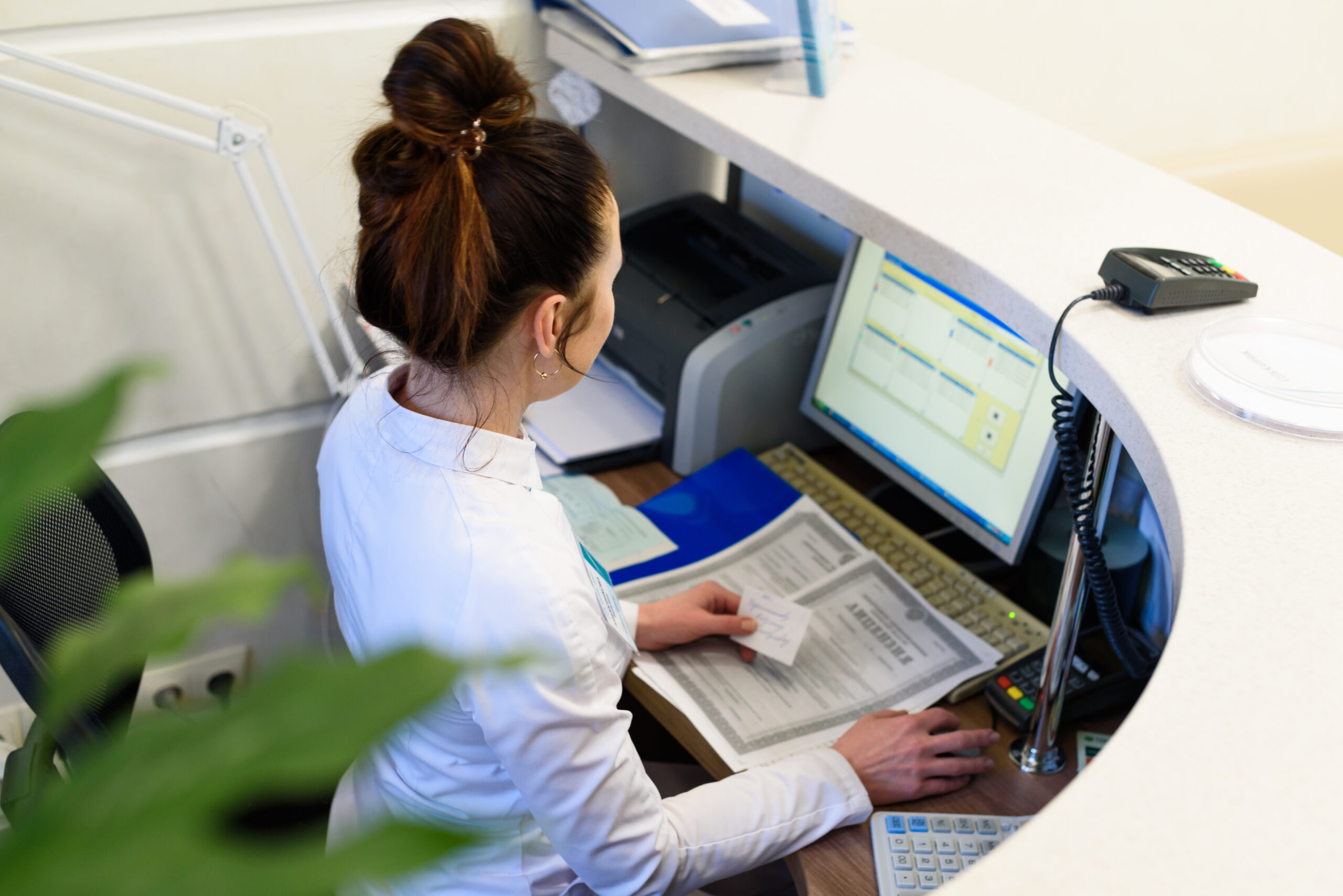 Female receptionist types on a computer