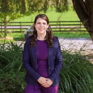 Caitlin Longan, a white woman, stands outside smiling.