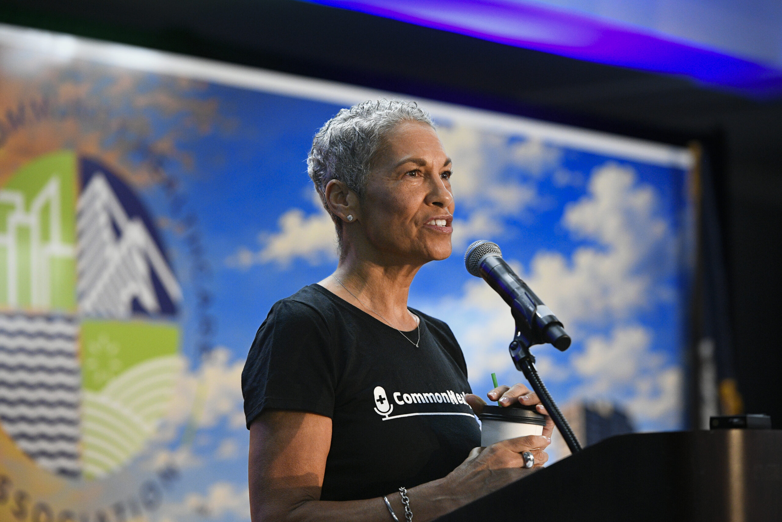 VCHA CEO Tracy Douglas speaks into a microphone on stage