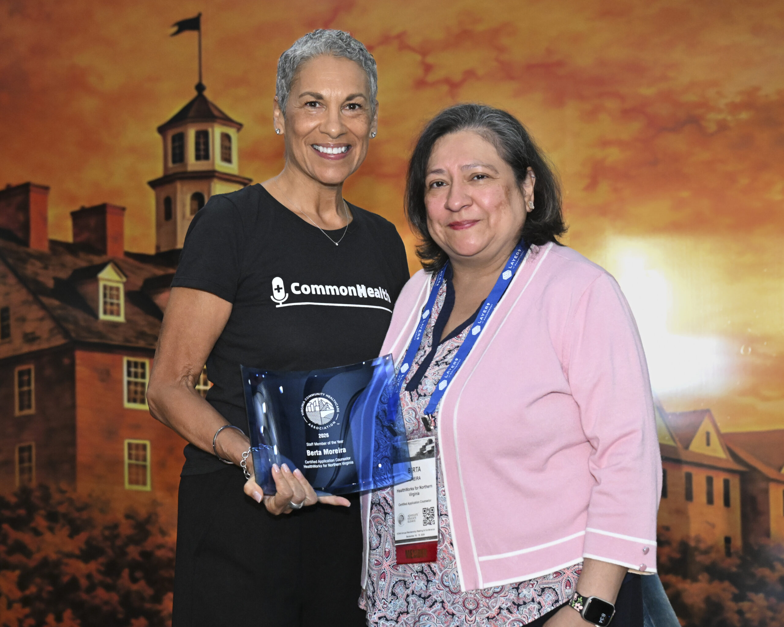 VCHA CEO Tracy Douglas and Berta Moreira, Certified Application Counselor at HealthWorks for Northern Virginia, smile while holding the Staff Member of the Year award