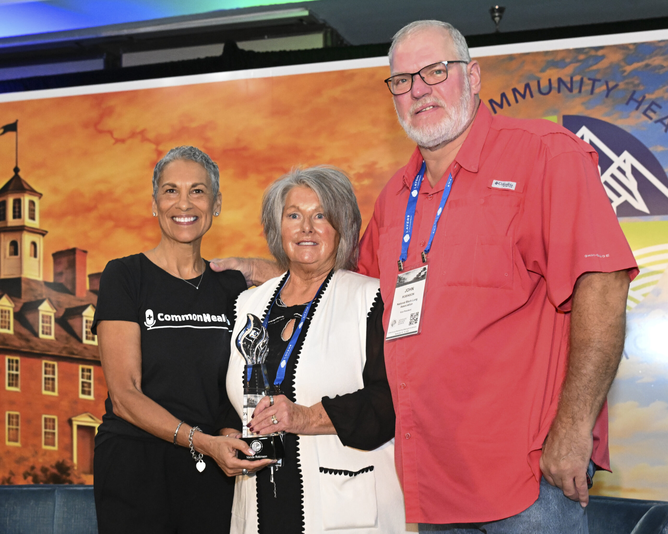 VCHA CEO Tracy Douglas, Vonda Robinson, President of the National Black Lung Association and Vonda's husband John, smile while holding the VCHA Torchbearer Award