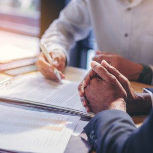 Stock photo of two businesspeople signing documents