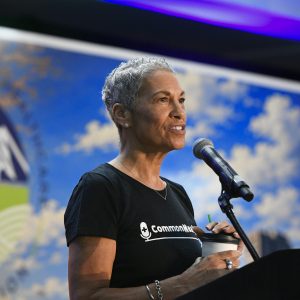 VCHA CEO Tracy Douglas speaks into a microphone on stage